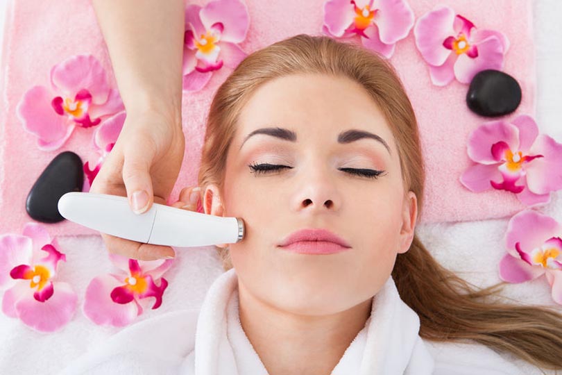High Angle View Of Woman Getting Microdermabrasion Therapy In Spa